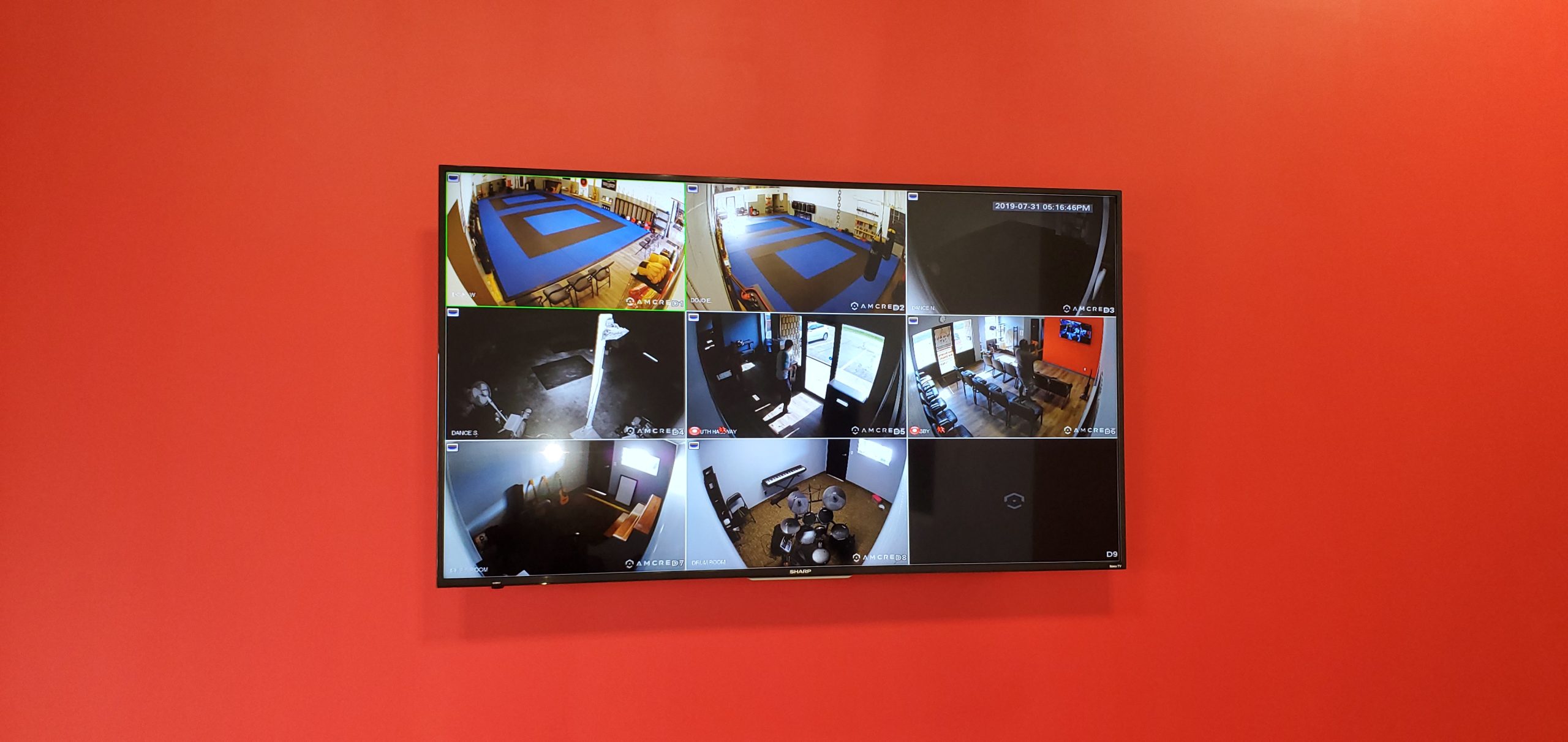 Multi-camera surveillance monitor mounted on a red wall